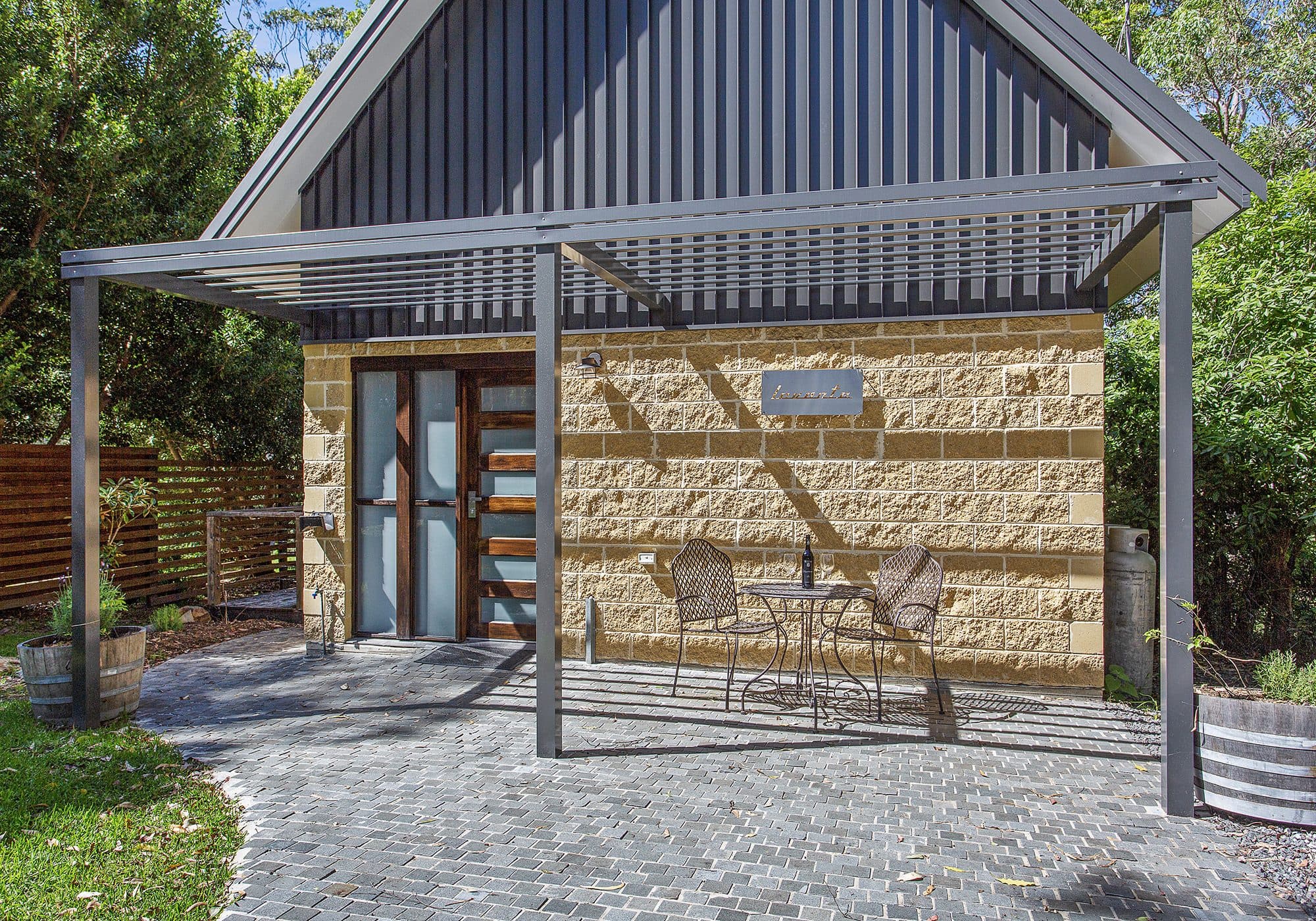 The Levante entry, with the cottage sign and a bistro table set for two, Serenity 222