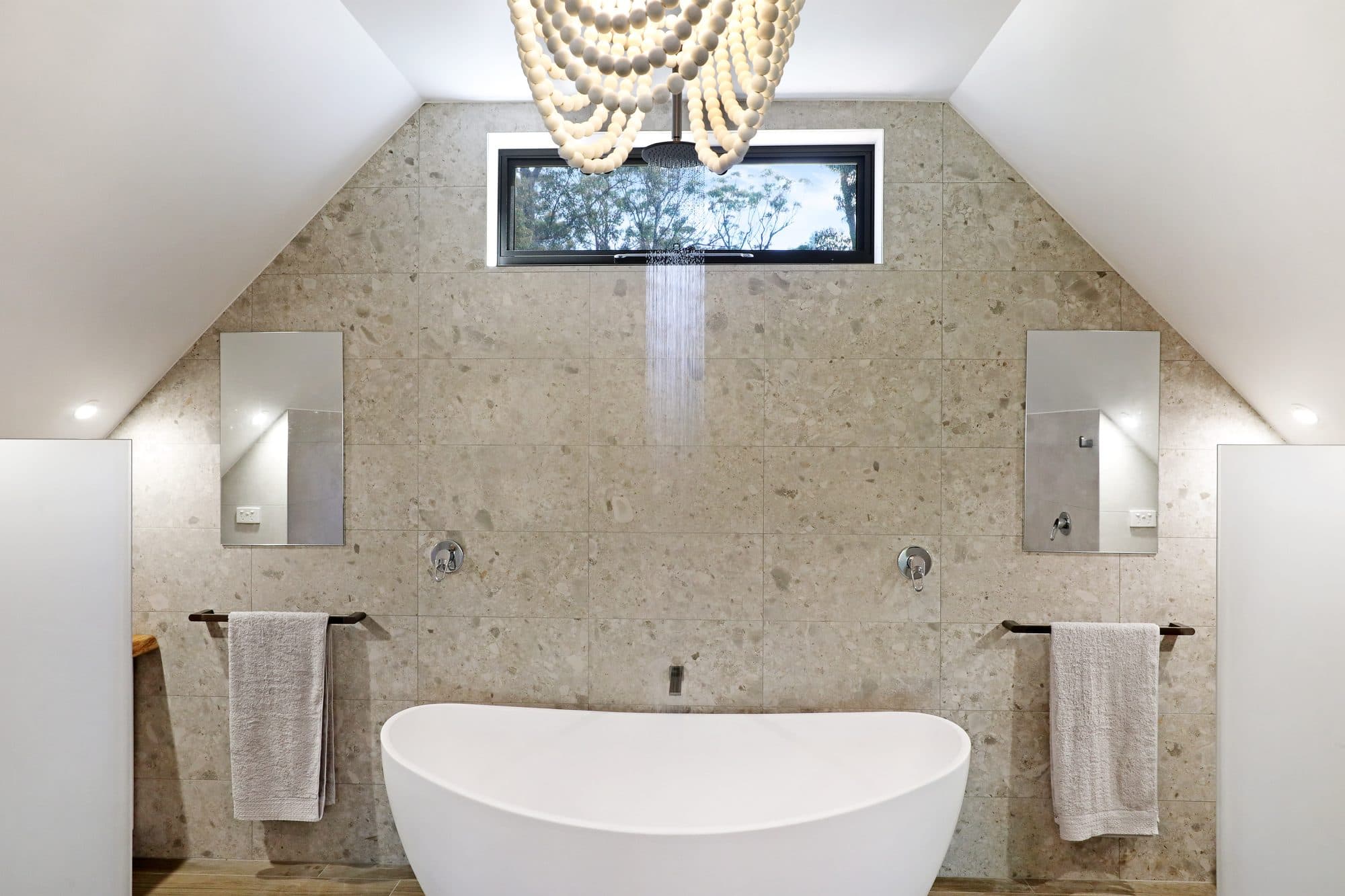 One of two bathrooms at Levante, Serenity 222 — warm, refined finishes