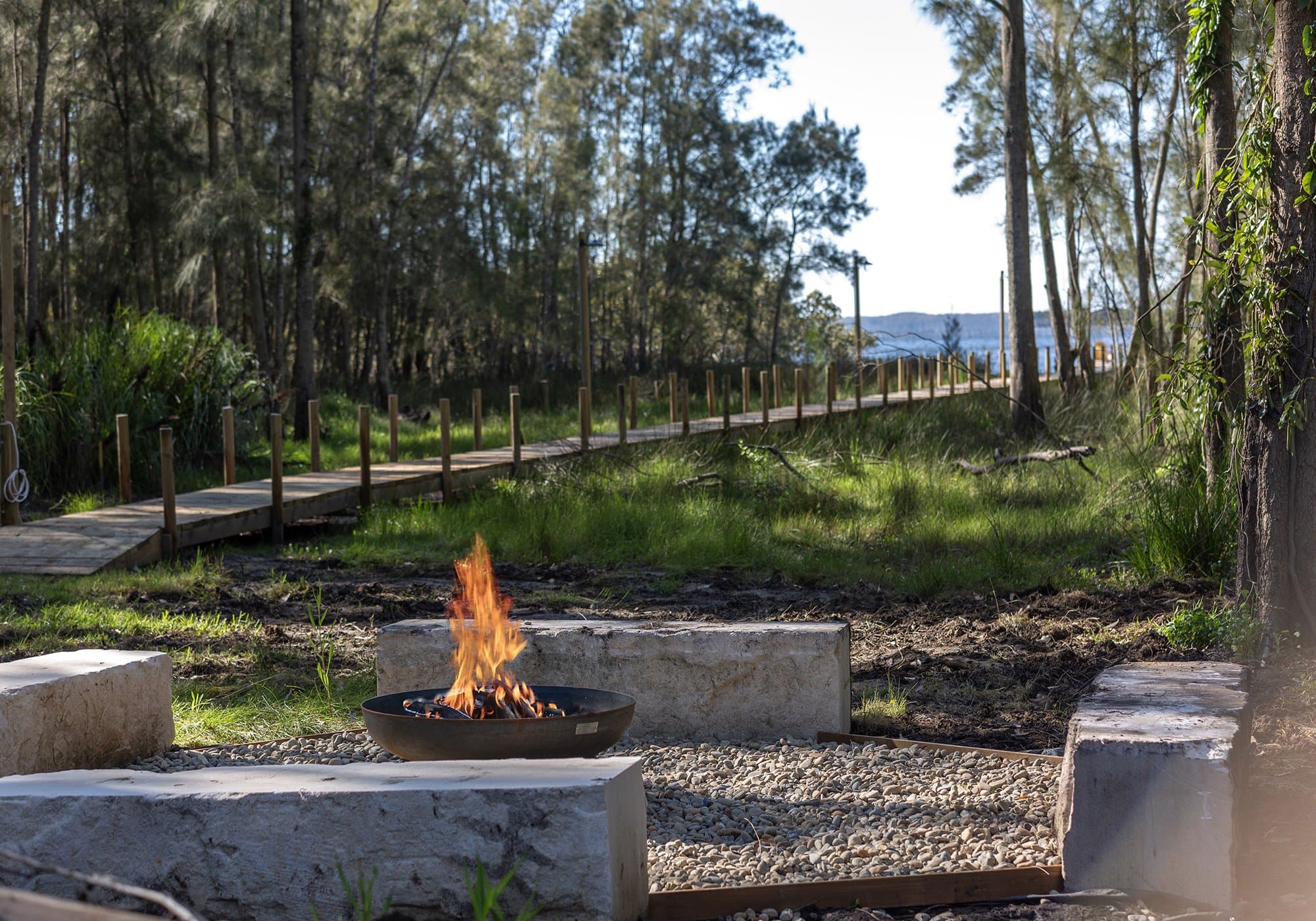 The communal firepit at Serenity 222, with the boardwalk to the Basin beyond